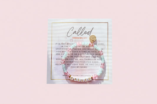 A handcrafted word bracelet displayed on a card with the word 'CALLED' written on it, along with a passage from Esther 4:14. The bracelet features beads in shades of blue and a charm with the word 'CALLED'.