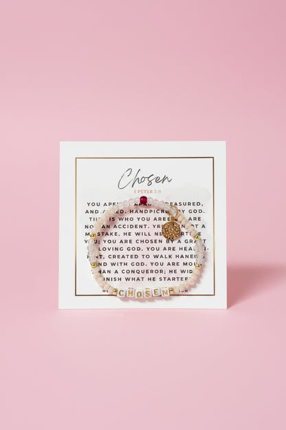 Gold bracelet with 'Chosen' charm on a card with text in a pink box